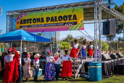 A folklorico group of elementary-age schoolchildren performs on an outdoor stage at Arizona Palooza