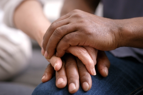 close-up of two hands clasped together in a show of support